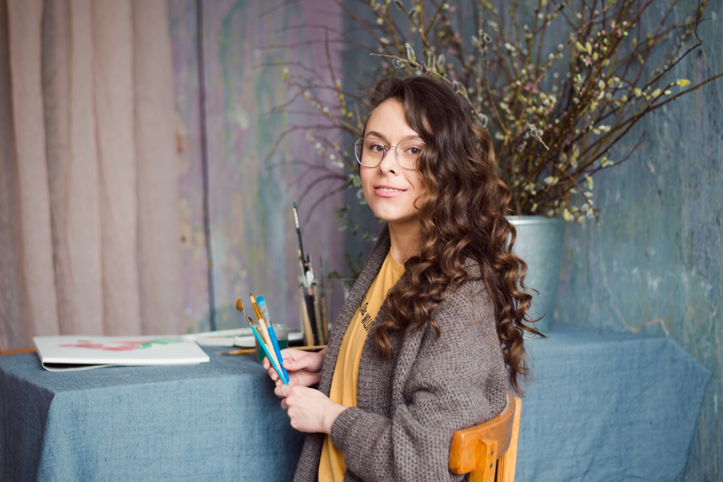 freelance artist on her work station holding art materials