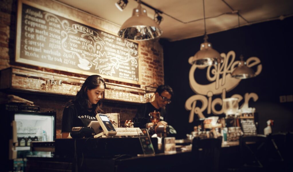 coffee shop staff members fulfilling the role of cashiers, which involves having a good cashier job description to succeed in their line of work