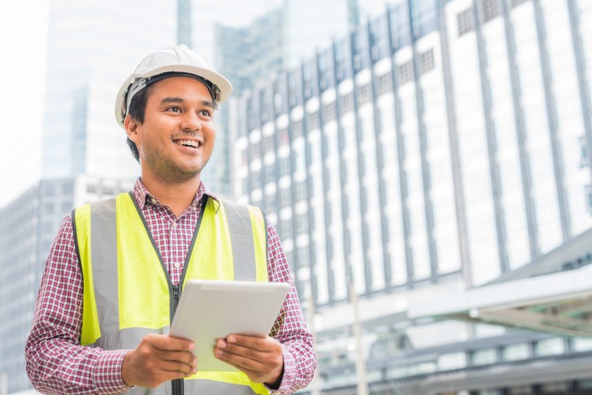 Man wearing hard hat holding a tablet showing construction project manager resume