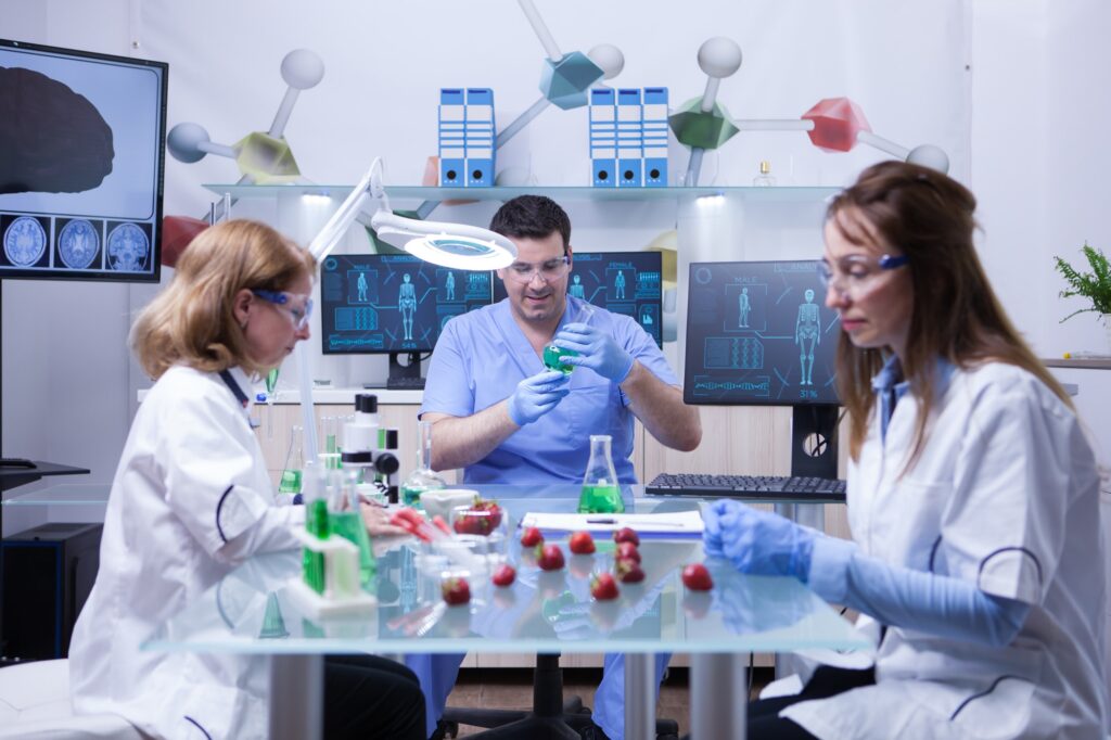 Young caucasian male scientist with two female scientist working in a lab research